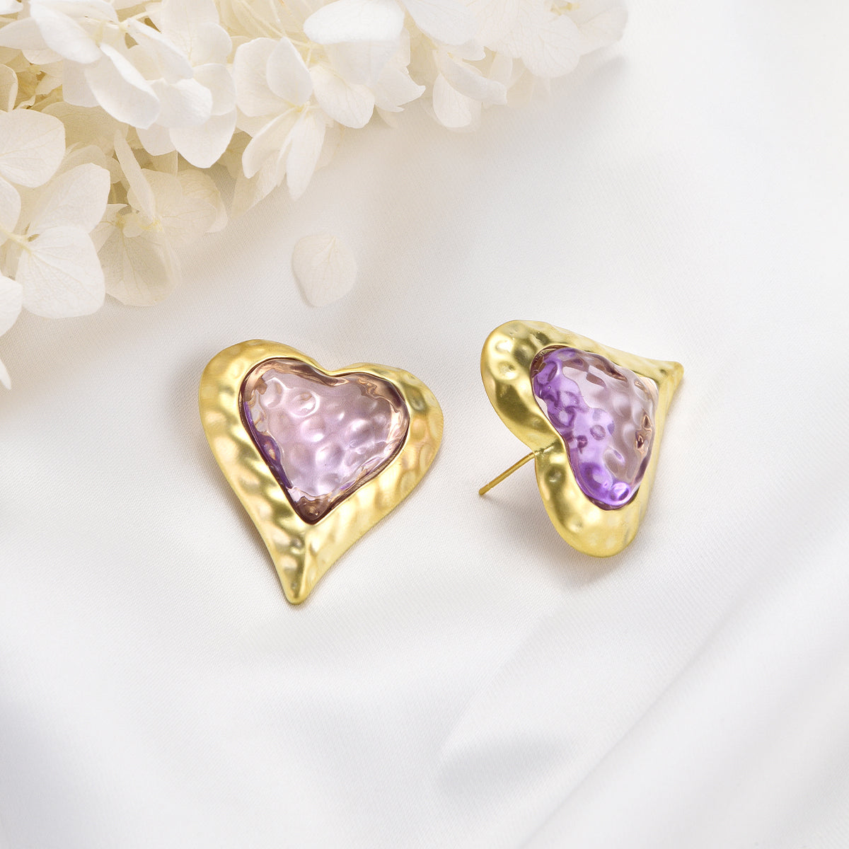 Cheerful pinkish earrings on golden heart shaped canvas