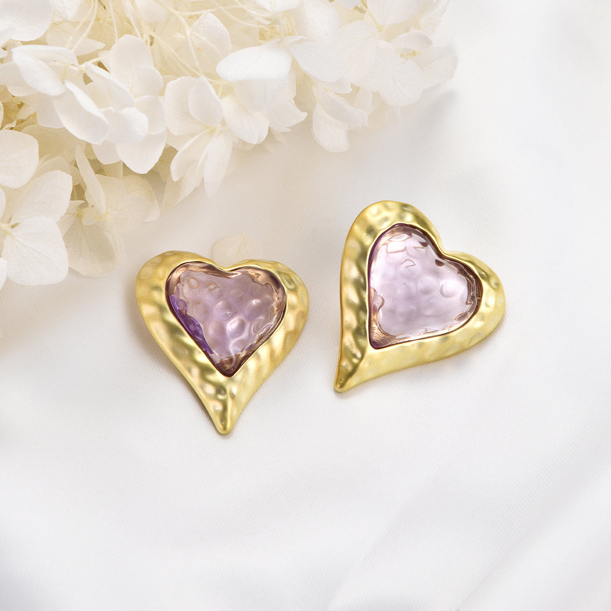 Cheerful pinkish earrings on golden heart shaped canvas