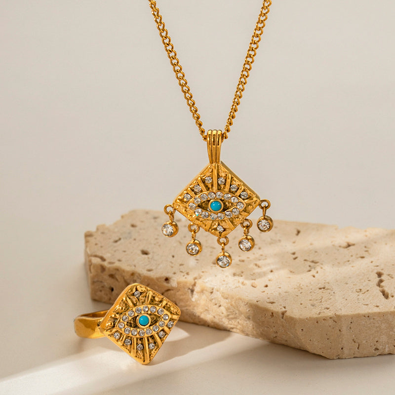 Set of golden necklace and ring with devout eye design jeweled with blue and white stones