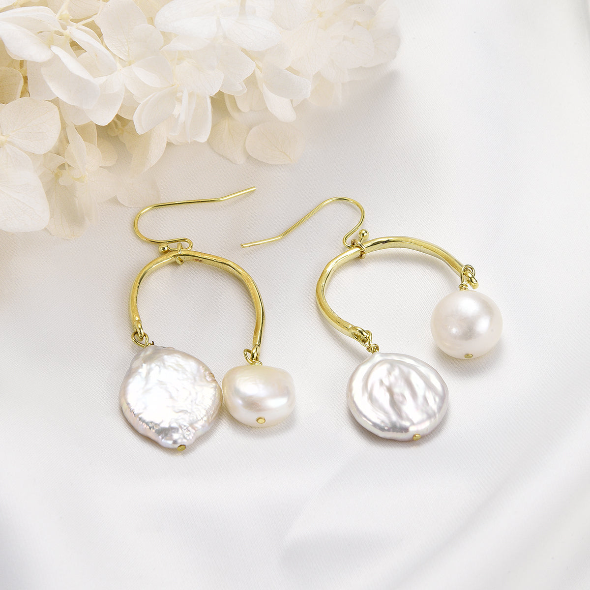 Twinning golden earrings with white pearls