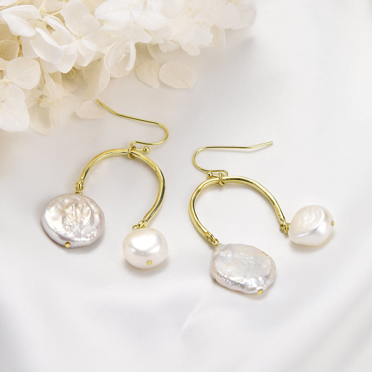 Twinning golden earrings with white pearls